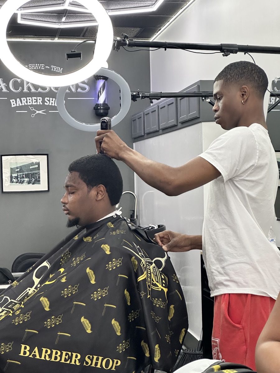 Barber working a fresh clipper cut in the chair at Jacksons Barbershop