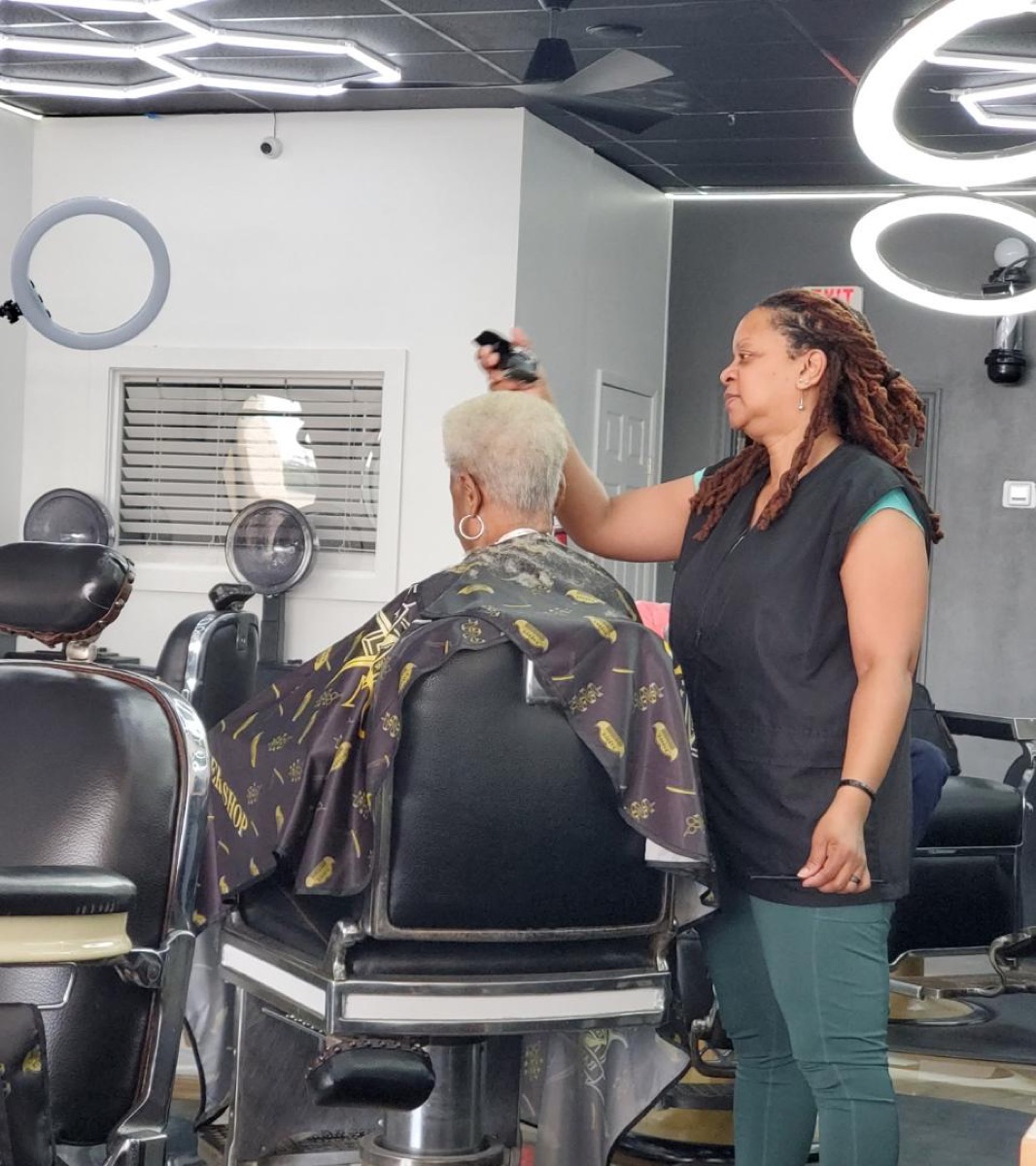 Barber styling a client under the studio lights at Jacksons Barbershop